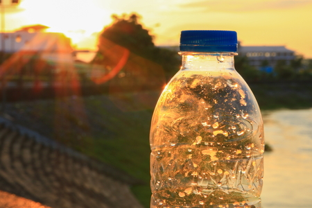 plastic water bottle on the stone floor in  a public park at sunset, sunrise timeの写真素材
