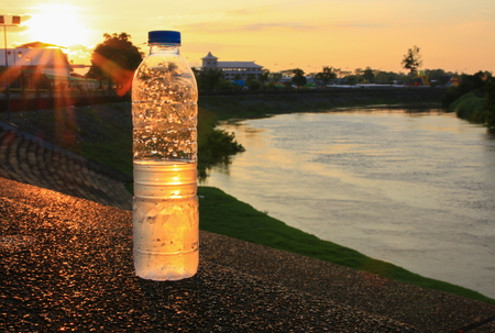 plastic water bottle on the stone floor in  a public park at sunset, sunrise timeの写真素材