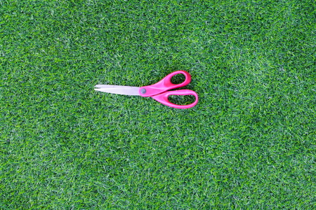 scissor red on artificial grass backgroundの写真素材