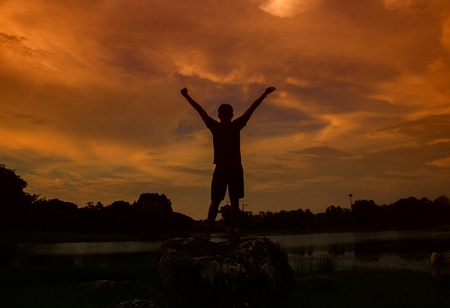 Silhouette of man meditating and yoga practicing with exercise at  sunrise in the morningの写真素材