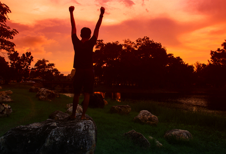 Silhouette of man meditating and yoga practicing with exercise at  sunrise in the morningの写真素材