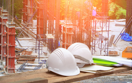 Plastic safety helmet and blueprint on wood andworker construction team working  building...
