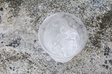 ice in glass-plastic on the floor background Top viewの写真素材