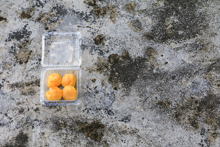 cream puffs in box plastic on the cement floor old with copy spaceの写真素材