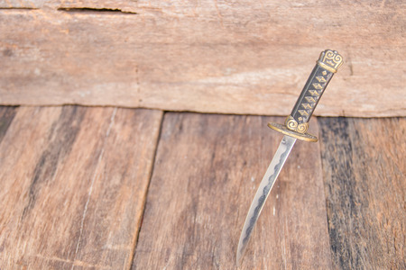 sword steel blade samurai pierce on old wooden surface floor with copy spaceの写真素材