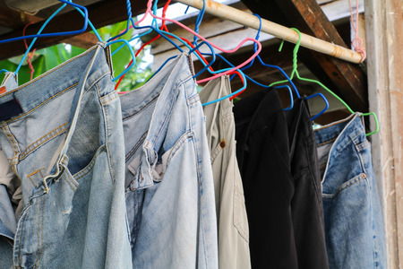 closeup blue jeans in a row on hangerの写真素材