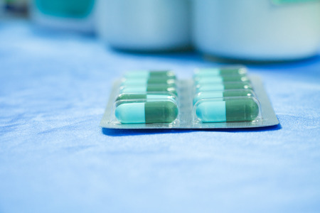 drug capsule green - azure or treatment medication in packages plastic pill. on  blue fabric table ...
