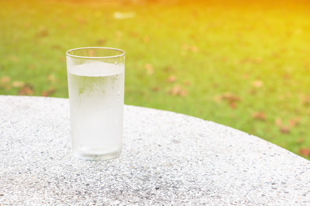 glass of water ice on terrazzo floor table with nature background and copy space add textの写真素材