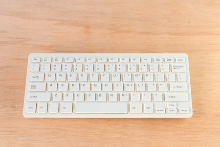 computer keyboard white on wooden floor with copy space add text  ( high definition image )の写真素材