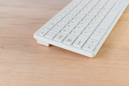 computer keyboard white on wooden floor with copy space add text  ( high definition image )の写真素材
