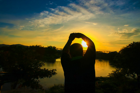 Silhouette of man obese exercise and yoga practicing in  sunrise  the morning with copy space add...