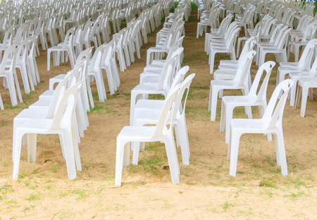 Row of white chairs plastic on lawn prepare business meetingの写真素材