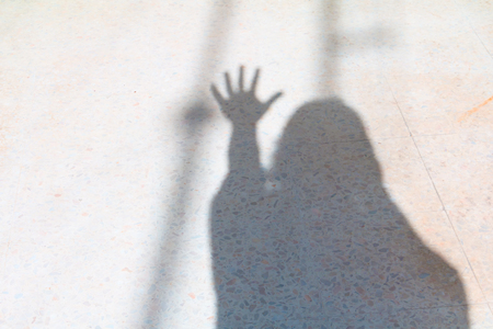 Blurry shadows of people and hand show counting number five on terrazzo floor halloween Conceptの写真素材