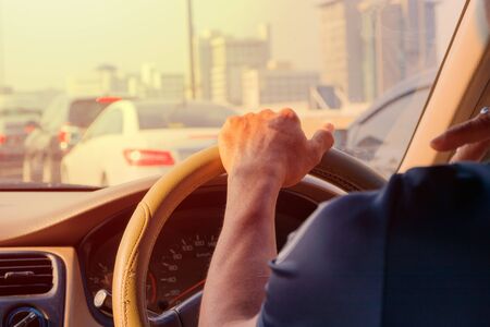hand of man driving car travel on road Traffic jam and sunlight