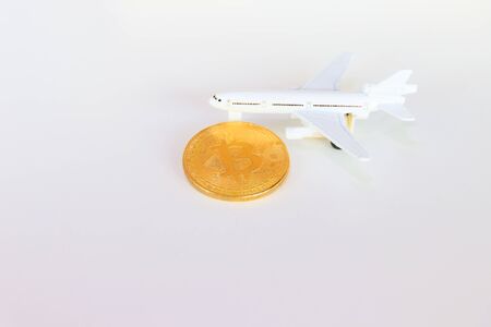 bitcoin coins and model of passenger plane  over white on black background. with copy space add textの写真素材