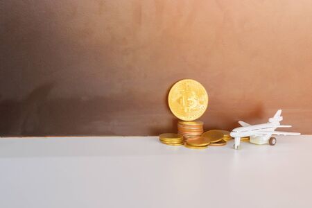 bitcoin coins and money stack and model of passenger plane  over white on black background. with...