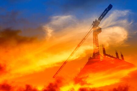 Silhouette Tower crane construction work on sunset time background and copy space add text concept...