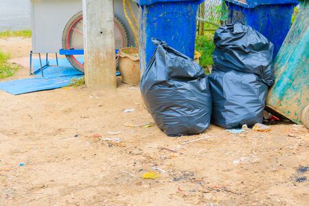 pile black garbage bag plastic and four dustbin dirty roadside in the city with copy space add text