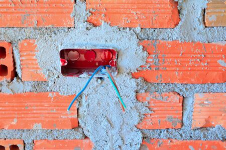 electricity wire construction in brick wall interior Construction site