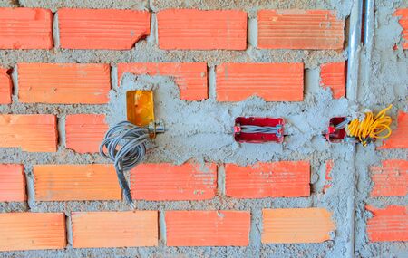 electricity wire construction in brick wall interior Construction siteの写真素材
