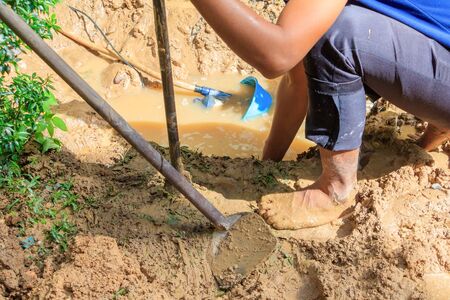 male plumber are repair broken pipe in hole with plumbing water flow outdoor and sunlight with copy...