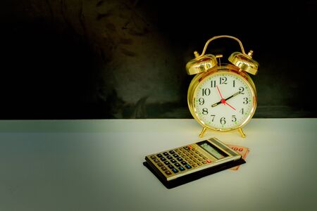 calculator and alarm clock old vintage gold over white and black background. with copy space add...
