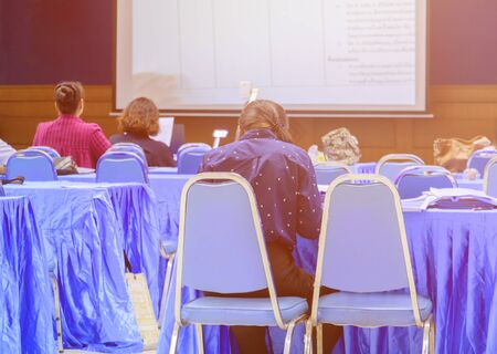 people backside in seminar business training conference meeting and screen project interior room with copy space add text. select focus with shallow depthの写真素材