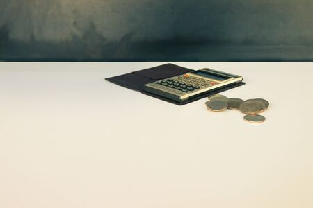 coin money and calculator old, book over white and black background with copy space add text. color vintage style toneの写真素材