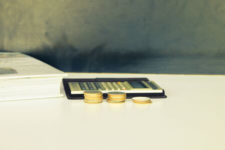 coin money and calculator old, book over white and black background with copy space add text. color vintage style toneの写真素材