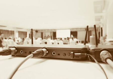 Close up Jack plug cables connected with old box of wireless microphone in conference meeting room seminar business blur. Vintage color toneの写真素材