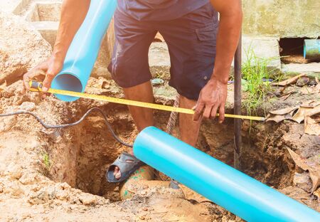 broken pipe in hole and water motion at roadside  plumber working repair with Measuring Tapeの写真素材