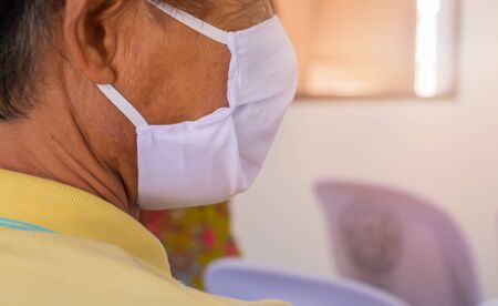 Close -up man using medical face mask fabric white prevent coronavirus or (Covid-2019)  in community city. concept prophylaxisの写真素材