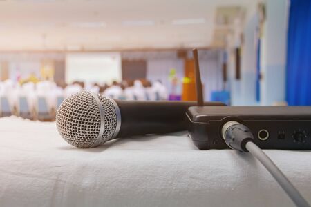 Close up old microphone wireless with box signal on the white table in business conference interior seminar meeting room and Background blur. Vintage toningの写真素材