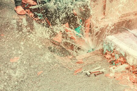 blur plumber working repair the broken pipe and replace   in hole with water Motion at roadside ( Teal and Orange Tone )の写真素材