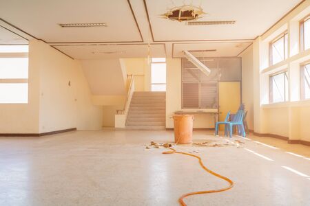 water leak drop interior office building in red bucket from gypsum ceiling and flow on terrazzo floorの写真素材