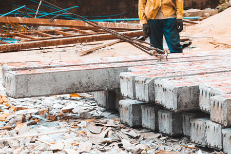 pile concrete pillars on the ground worker move by sling in construction site