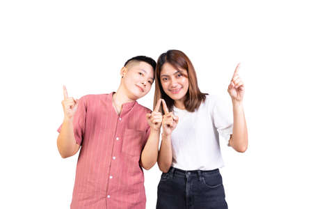 Two young girls friends smile happiness pointing finger up happy isolated on white backgroundの写真素材