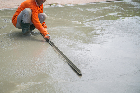Construction pouring cement during sidewalk upgradeの写真素材