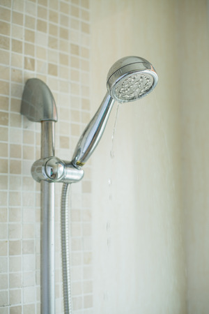 shower head in bathroom with water drops flowingの写真素材