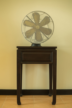 Classic antique fan placed on a wooden table.の写真素材