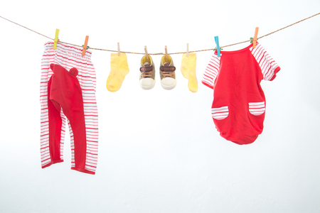 Baby clothes hanging on the rack isolated on white background.の写真素材