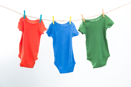 Baby clothes hanging on the rack isolated on white background.の写真素材