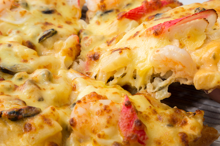 Hot piece of pizza with melted cheeseの写真素材