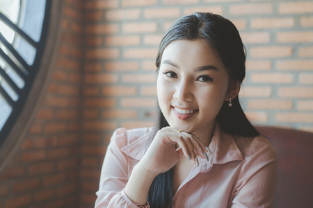 Asian beautiful smiling business womanover in coffee shop cafe vintage colorの写真素材