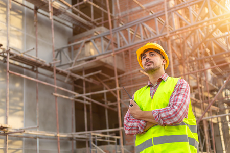 Manager Engineering in standard safety uniform working in a pouring concrete pump on construction siteの写真素材