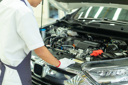 Auto mechanic working in garage, Car Repair Service center.の写真素材
