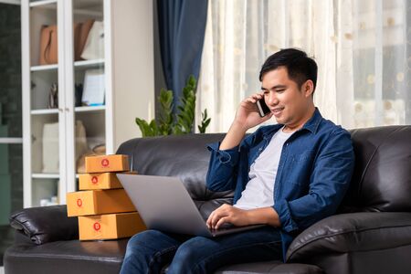 Online sales young start small business in a cardboard box at work. The seller prepares the delivery box for the customer, or ecommerce. Work from home concept.の写真素材