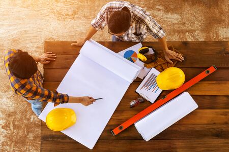 [top view Construction Teamwork ] Team of engineer and architects working, meeting, discussing,designing, planing, measuring layout of building blueprints in construction site floor at factory.の写真素材