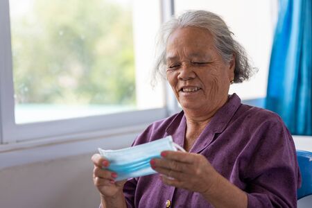 Senior asian woman wearing face mask during corona virus and flu outbreak. Disease and illness protection. the aging female patient that is at risk for infection corona virus [covid-19].の写真素材