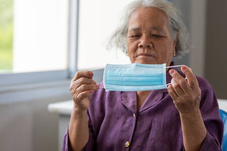 Senior asian woman wearing face mask during corona virus and flu outbreak. Disease and illness protection. the aging female patient that is at risk for infection corona virus [covid-19].の写真素材